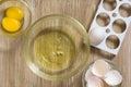 Separated raw chicken yolk and whites on wooden table