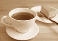 Sepia Image of a Cup of Hot Tea with Baked Cheesecake in Background