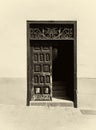 Sepia image of an old wooden door with panels in a traditional spanish house half open revealing stairs inside decorative ironwo Royalty Free Stock Photo