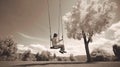 Sepia image of woman on a swing in the park