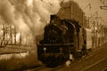 Sepia old steam train in clouds of smoke rides by rail Royalty Free Stock Photo