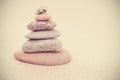 Sepia retro stylized stone pyramid on sand, harmony and balance