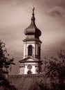 Sepia shot of a church bell tower against cloudy sky