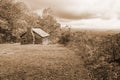 Sepia Tone Image of a Log Cabin, Valley and Stormy Clouds Royalty Free Stock Photo