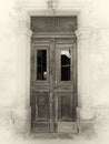 Sepia view of a broken old double doors a traditional abandoned spanish house with broken windows and faded peeling paint Royalty Free Stock Photo