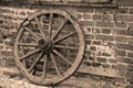 Sepia vintage iron gate in front of a mossy brick wall.