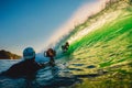 September 8, 2018. Bali, Indonesia. Surfer ride in barrel wave and surf photographer at sunset. Professional surfing in ocean