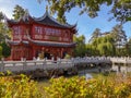 Tea pavilion in traditional red color with blue roof beams in the Chinese garden in the wildlife park Pairi Daiza