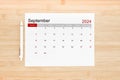 September 2024 calendar page on wooden background