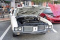 Classic white car with hood up.