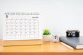 The September monthly desk calendar for 2023 year and a vintage camera against on the table. Travel concepts