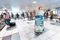 Female tourist with medical protective antiviral mask with cargo cart at Domodedovo airport