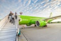 passengers walk down the ramp from the cabin of the S7 airline at Domodedovo airport