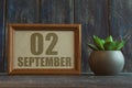 september 2nd. Day 2 of month, date in frame next to succulent on wooden background autumn month, day of the year concept Royalty Free Stock Photo