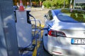 September 2020 Parma, Italy: Tesla Car recharging on charging station. Power supply plugged into an electric car being charged.