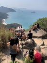 Tourists of different nationalities in line to take the picture on the rock.