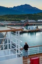 September 15, 2018 - Skagway, AK: Cruise ship passenger overlooking harbour from docking ship at sunrise.