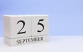 September 25st. Day 25 of month, daily calendar on white table with reflection, with light blue background. Autumn time, empty