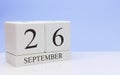 September 26st. Day 26 of month, daily calendar on white table with reflection, with light blue background. Autumn time, empty