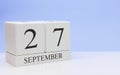 September 27st. Day 27 of month, daily calendar on white table with reflection, with light blue background. Autumn time, empty