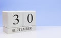 September 30st. Day 30 of month, daily calendar on white table with reflection, with light blue background. Autumn time, empty