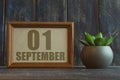 september 1st. Day 1 of month,  date in frame next to succulent on wooden background autumn month, day of the year concept Royalty Free Stock Photo
