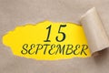 september 15. 15th day of the month, calendar date.Hole in paper with edges torn off. Yellow background is visible