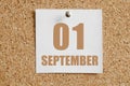 September 01. 01th day of the month, calendar date.White calendar sheet attached to brown cork board.Autumn month, day of the year