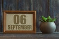 september 6th. Day 6 of month, date in frame next to succulent on wooden background autumn month, day of the year concept Royalty Free Stock Photo