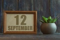 september 12th. Day 12 of month, date in frame next to succulent on wooden background autumn month, day of the year concept Royalty Free Stock Photo