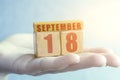 september 18th. Day 18 of month,Handmade wood cube with date month and day on female palm autumn month, day of the year concept