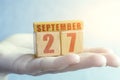 september 27th. Day 27 of month,Handmade wood cube with date month and day on female palm autumn month, day of the year concept Royalty Free Stock Photo