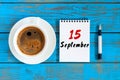 September 15th. Day 15 of month, hot coffee cup with loose-leaf calendar on accauntant workplace background. Autumn time