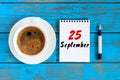 September 25th. Day 25 of month, loose-leaf calendar and cappuccino cup at Administrator workplace background. Autumn