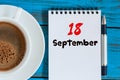 September 18th. Day 18 of month, morning cappuccino cup with loose-leaf calendar on analyst workplace background. Autumn