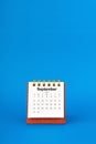 September 2024 white desk calendar on blue background