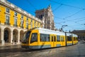 Yellow tram carrier stopped at Praca do Comercio and Arco da Rua Augusta
