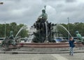 Young boy takes selfie in front of Neptunbrunnen fountain, Berlin, Germany