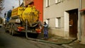 OLOMOUC, CZECH REPUBLIC, JANUARY, 20, 2021: Cesspool septic emptying pumping into pipe tank truck suction hose under Royalty Free Stock Photo