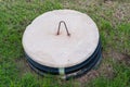 Septic tank lid in the middle of a yard.