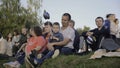 Serbia, Belgrade - June 20, 2023: People are sitting on grass and watching summer concert. Clip. Families with children