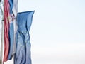 Serbian and European flags waiving in the air with a blue sky background.