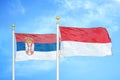 Serbia and Indonesia two flags on flagpoles and blue sky