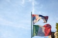 Flags of italy and Serbia waiving together at a pole in Serbia.