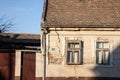 Cracked facade of a stone wall of an old and decaying building, heavily needing renovation on an abandoned farmhouse