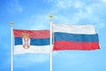 Serbia and Russia two flags on flagpoles and blue sky