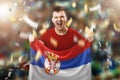 A Serbian fan, a fan of a man holding the national flag of Serbia in his hands. Soccer fan in the stadium. Mixed media Royalty Free Stock Photo