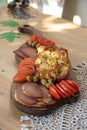 Serbian traditional food plate contain beef and pork smoked dried meet, cheese, vegetables and proja bread made of corn flour