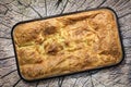 Serbian Traditional Gibanica Crumpled Cheese Pie In Baking Pan Set On Top Of Old Weathered Cracked Stump Picnic Table