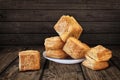 Bunch Of Freshly Baked Small Square Sesame Puff Pastry Zu-Zu Set On Rustic Knotted Wood Background